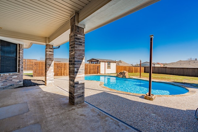 view of pool featuring a patio and a shed