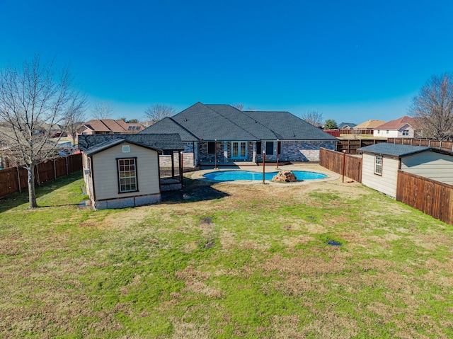 back of property featuring a fenced in pool and a lawn