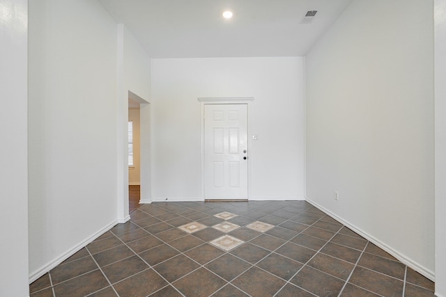 unfurnished room featuring dark tile patterned flooring