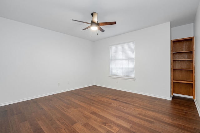 empty room featuring dark wood-type flooring and ceiling fan