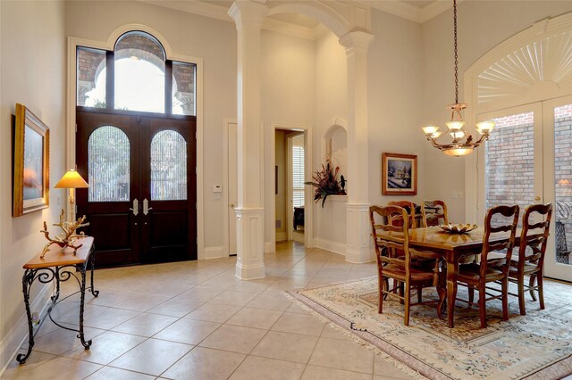 foyer entrance featuring crown molding, french doors, and ornate columns