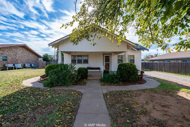 view of front of house with a front yard and a porch