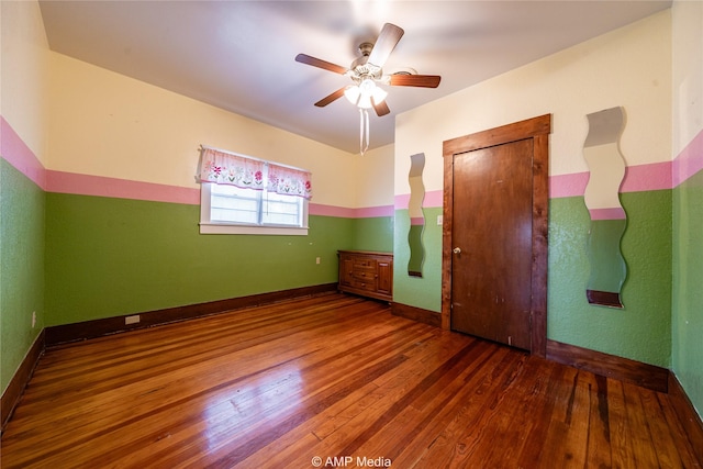 unfurnished room with ceiling fan and dark hardwood / wood-style floors