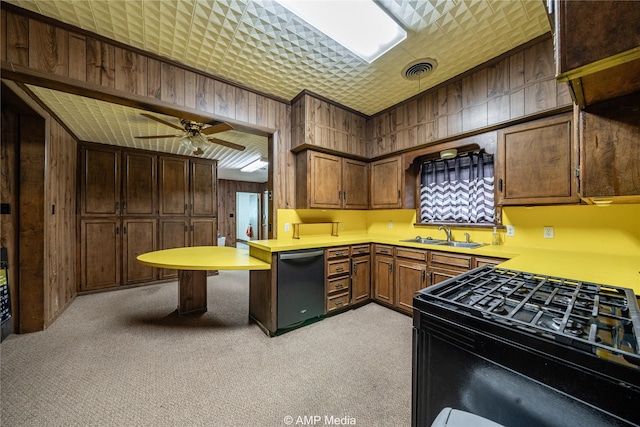 kitchen featuring sink, ceiling fan, wooden walls, black appliances, and light colored carpet