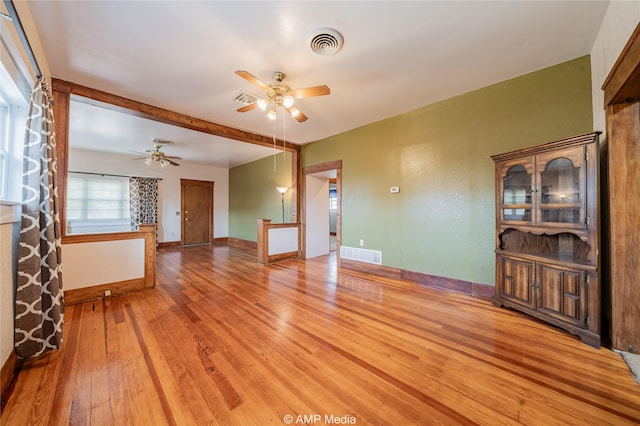 living room featuring beam ceiling, hardwood / wood-style floors, and ceiling fan