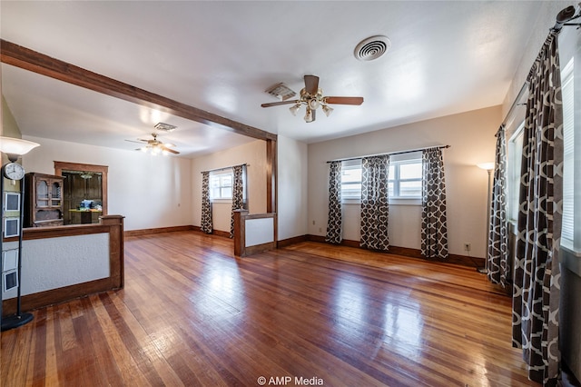 living room with a wealth of natural light, dark wood-type flooring, and ceiling fan