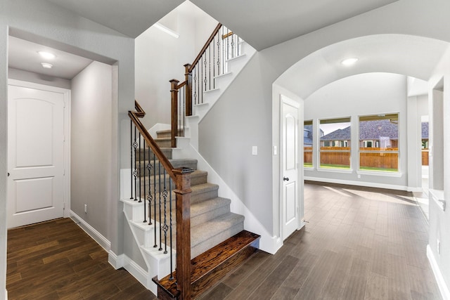 stairs featuring hardwood / wood-style flooring and vaulted ceiling