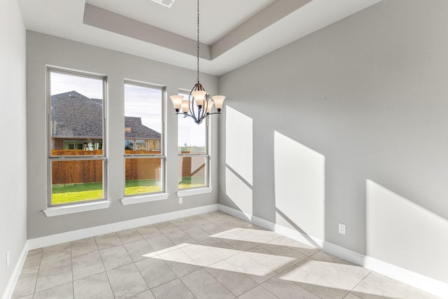 unfurnished dining area with a chandelier, a raised ceiling, and light tile patterned floors