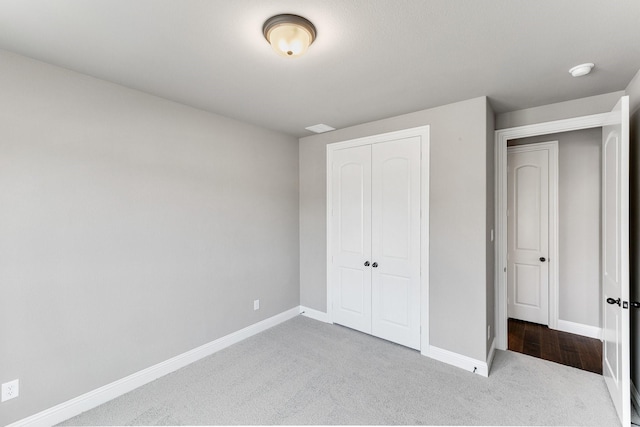 unfurnished bedroom with light carpet and a closet