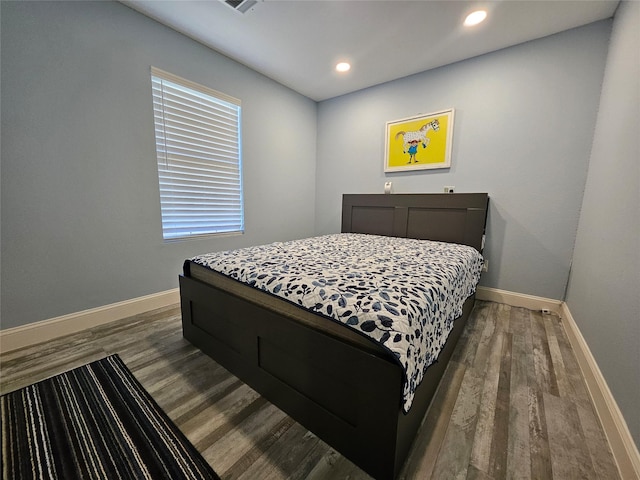 bedroom featuring multiple windows and dark hardwood / wood-style floors