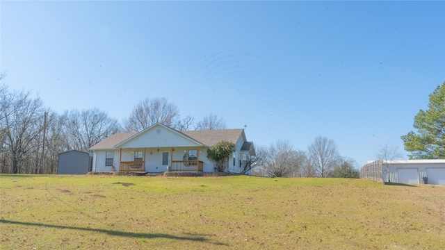 view of front facade featuring an outdoor structure, covered porch, and a front lawn