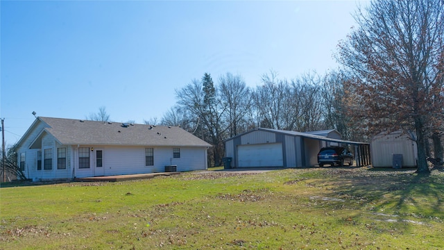 back of property with central AC, a storage shed, a yard, and a garage