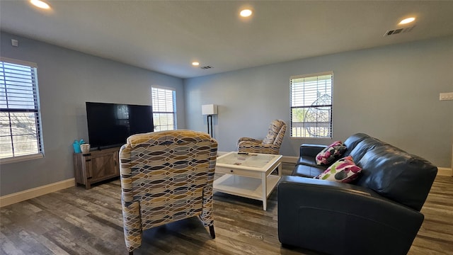 living room featuring a healthy amount of sunlight and dark hardwood / wood-style flooring