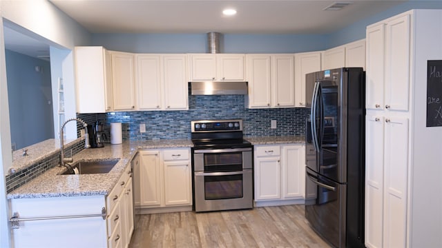 kitchen with sink, refrigerator, double oven range, light stone countertops, and white cabinets