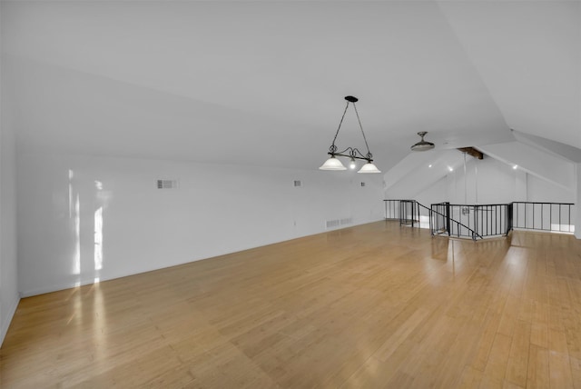 unfurnished living room featuring lofted ceiling and light hardwood / wood-style flooring