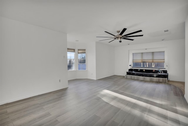 unfurnished living room with ceiling fan and light hardwood / wood-style flooring