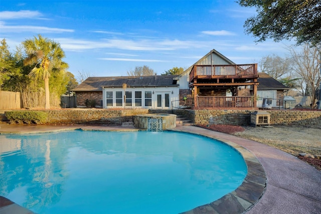 view of pool with a wooden deck and pool water feature