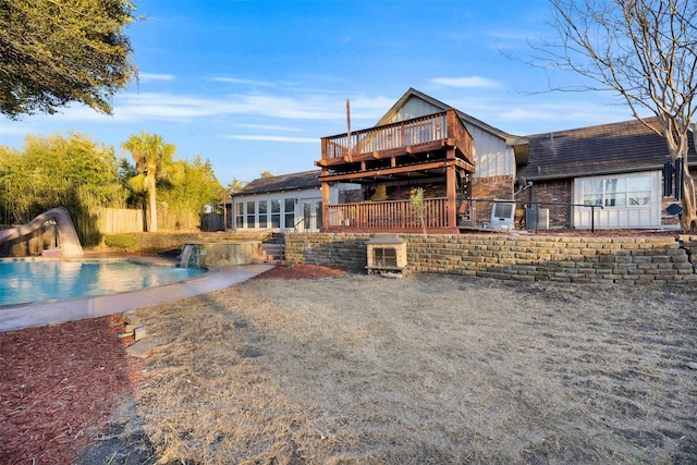 rear view of house featuring pool water feature and a swimming pool side deck