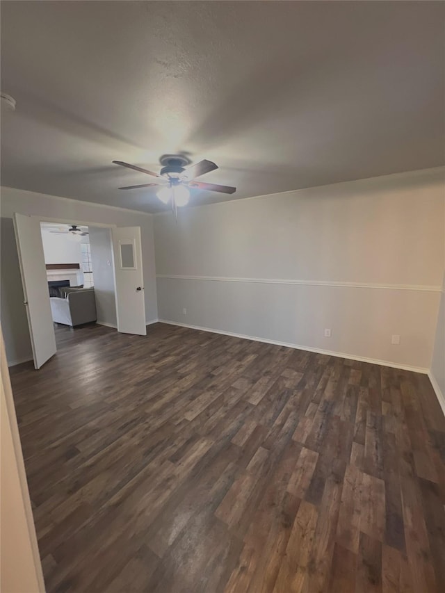 unfurnished living room featuring dark hardwood / wood-style floors and ceiling fan