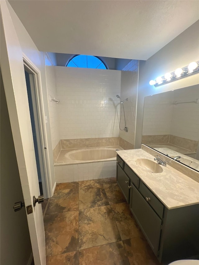 bathroom featuring tiled shower / bath combo and vanity