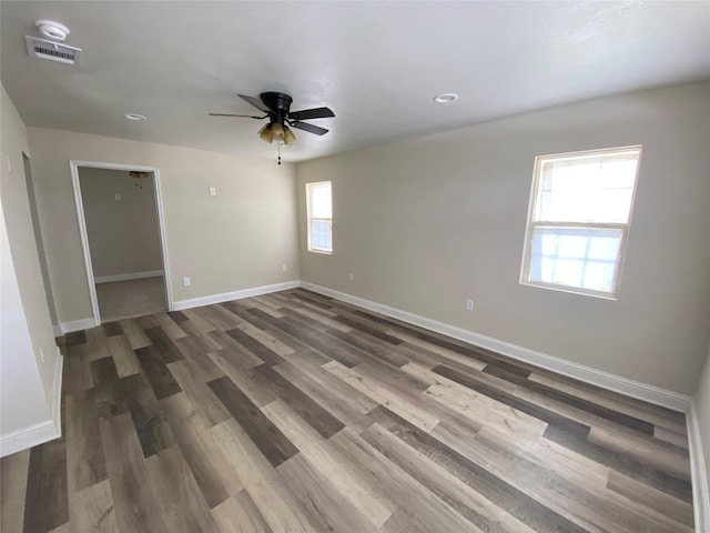 empty room featuring dark hardwood / wood-style flooring and ceiling fan