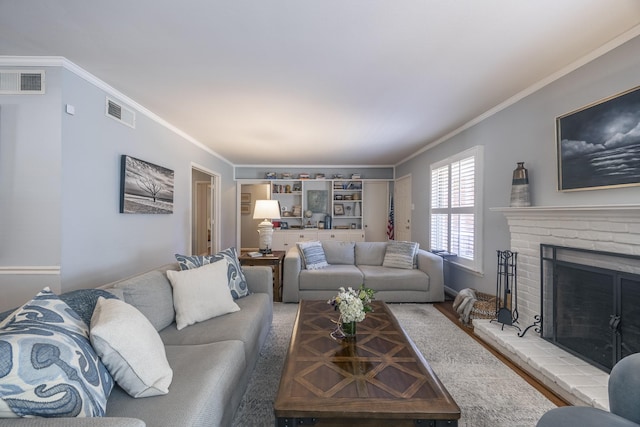 living room featuring crown molding, a fireplace, and hardwood / wood-style floors