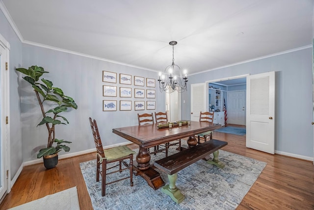 dining space with an inviting chandelier, hardwood / wood-style floors, and crown molding