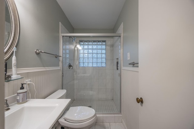 bathroom featuring a shower with shower door, sink, and toilet