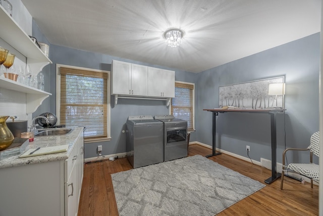 laundry area with cabinets, dark hardwood / wood-style flooring, sink, and independent washer and dryer