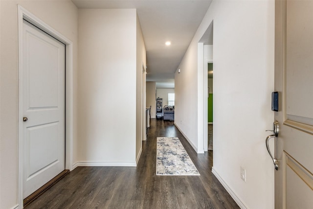 corridor with dark hardwood / wood-style flooring