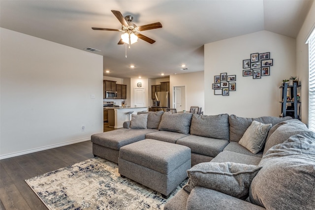 living room with dark hardwood / wood-style flooring, vaulted ceiling, and ceiling fan