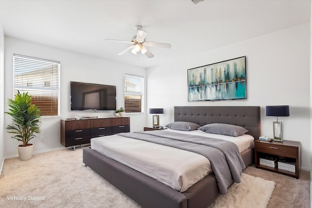 carpeted bedroom with multiple windows and ceiling fan