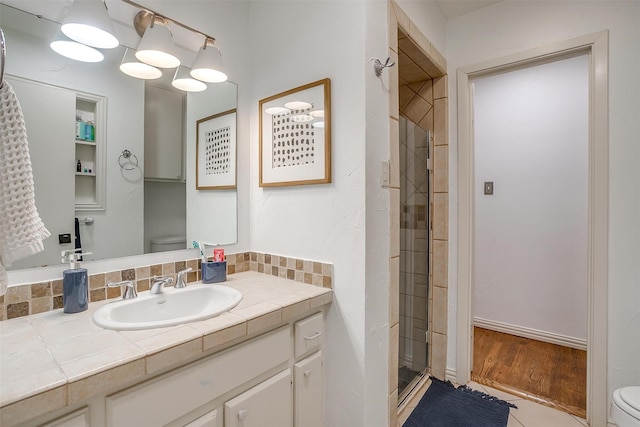 bathroom featuring walk in shower, vanity, and toilet