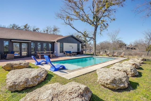 view of swimming pool with french doors and a patio