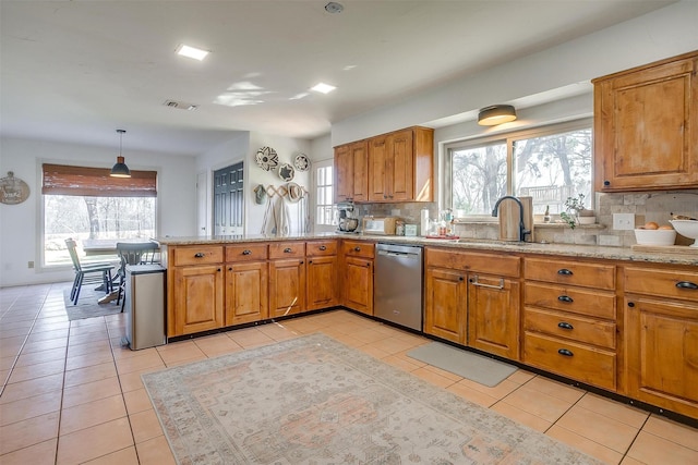 kitchen with light tile patterned floors, decorative light fixtures, and dishwasher