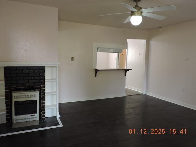 unfurnished living room with dark hardwood / wood-style flooring, heating unit, ceiling fan, and a fireplace