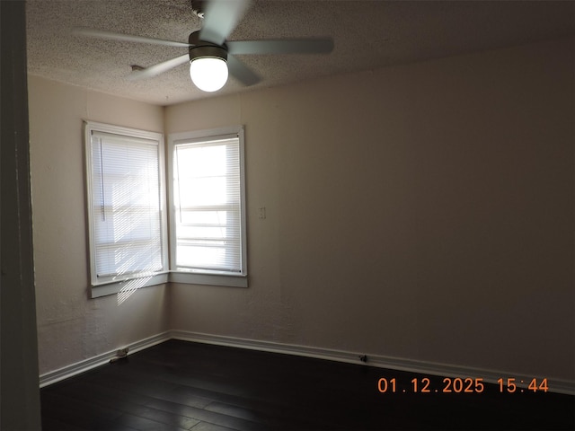 spare room featuring dark hardwood / wood-style flooring, ceiling fan, and a textured ceiling