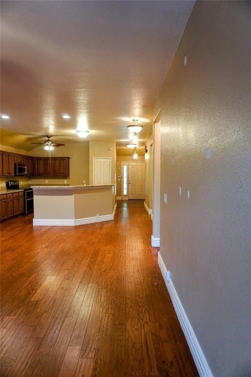 unfurnished living room with hardwood / wood-style flooring and ceiling fan