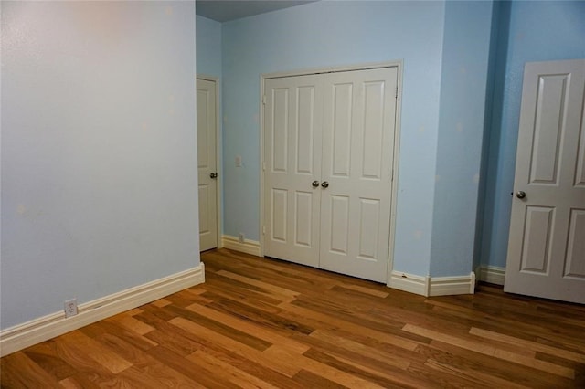 unfurnished bedroom with hardwood / wood-style flooring and a closet