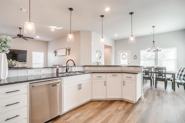 kitchen featuring pendant lighting, stainless steel dishwasher, sink, and white cabinets