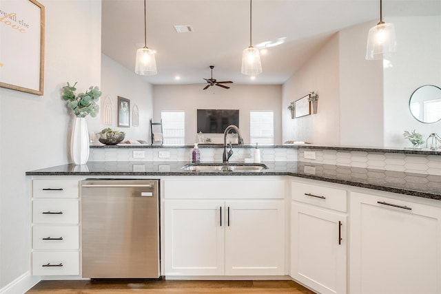 kitchen featuring sink, white cabinetry, dishwasher, pendant lighting, and dark stone counters