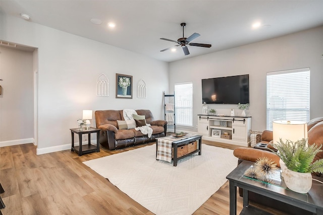 living room featuring ceiling fan and light hardwood / wood-style flooring