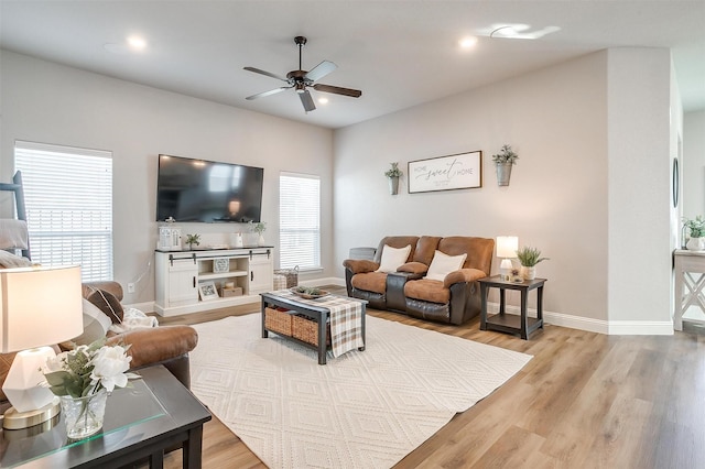 living room with a healthy amount of sunlight, ceiling fan, and light hardwood / wood-style flooring