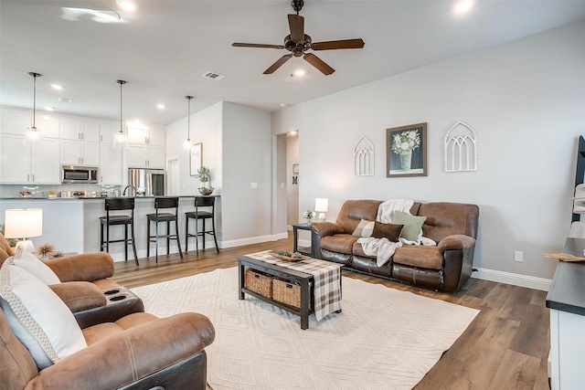 living room with ceiling fan and light wood-type flooring