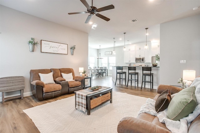 living room featuring light hardwood / wood-style floors and ceiling fan