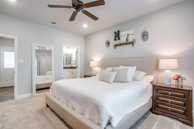 carpeted bedroom with sink, ensuite bath, and ceiling fan