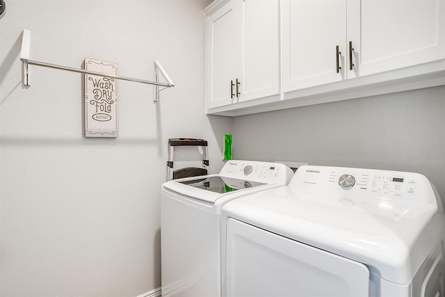 washroom featuring cabinets and washing machine and clothes dryer