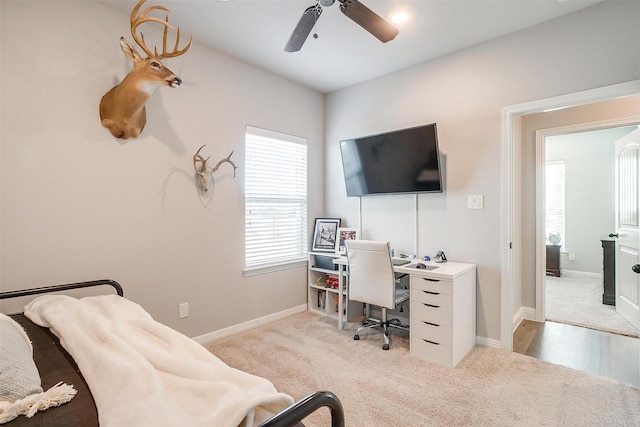 home office featuring light carpet and ceiling fan