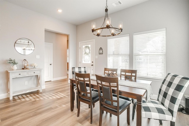 dining area with an inviting chandelier and light hardwood / wood-style floors