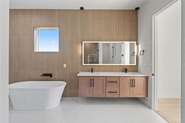 bathroom with tile patterned flooring, a bathing tub, and vanity